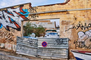 Europa, Portugal, Algarve, Litoral, Sotavento, Distrikt Faro, Olhao, brüchige Steinmauer mit Graffiti, provisorisch versperrter Zugang Europa, Portugal, Algarve, Litoral, Sotavento, Distrikt Faro, Olhao, brüchige Steinmauer mit Graffiti, provisorisch versperrter Zugang